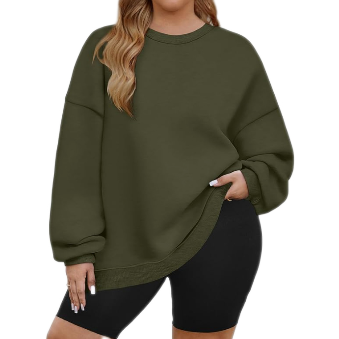 A person is wearing an oversized olive green sweatshirt paired with black cycling shorts.