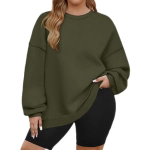 A person is wearing an oversized olive green sweatshirt paired with black cycling shorts.