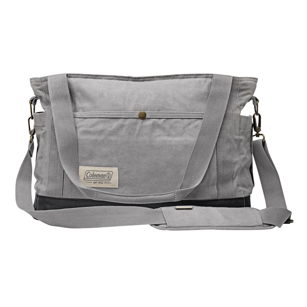 The 18\“ Coleman Soft Cooler Tote is a gray canvas bag featuring a front pocket, adjustable shoulder strap, and dual handles. It includes the \“Coleman\“ logo tag and metal hardware for secure closures.