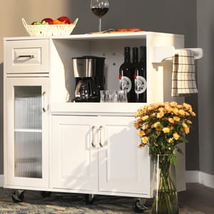 White kitchen cart with a wine rack, towel bar, and storage cabinets next to a vase of flowers.