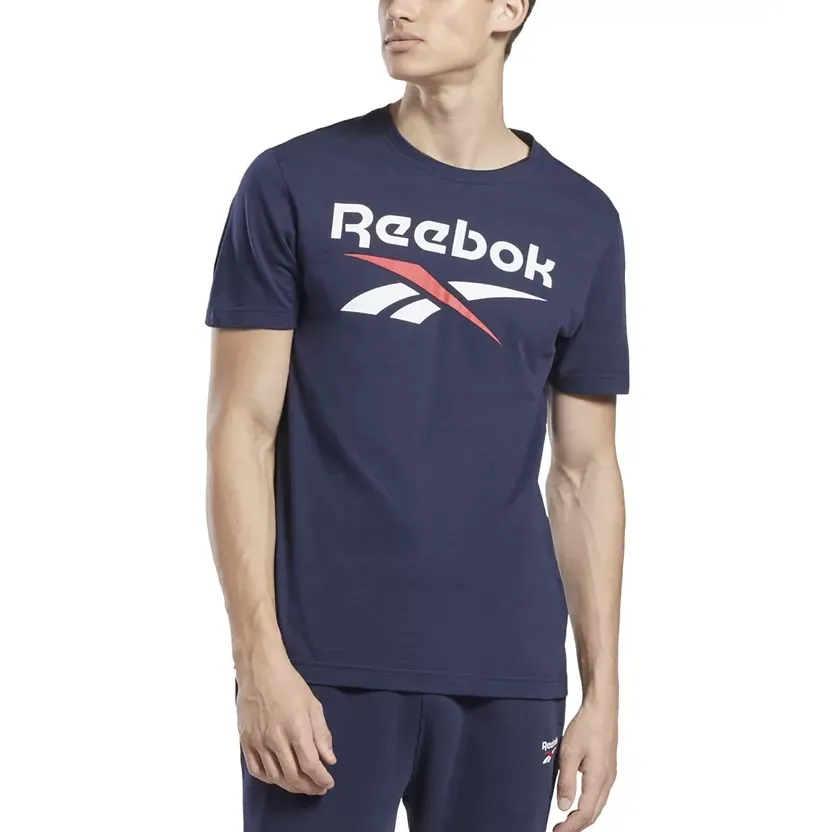 A man wearing a dark blue Reebok t-shirt with the brand's logo on the front and matching shorts.