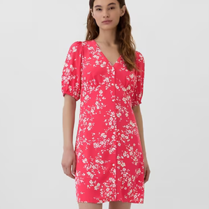 A red mini dress with a white floral pattern, featuring short sleeves and a V-neckline.