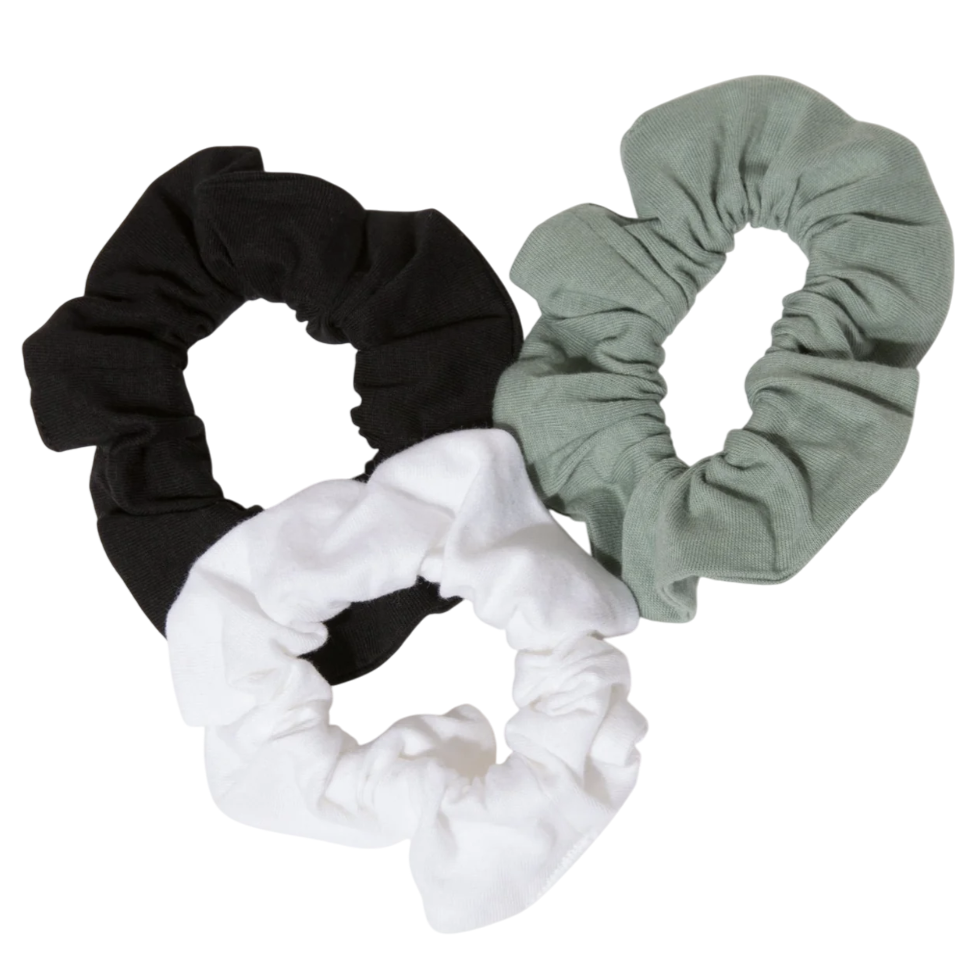 Three fabric scrunchies in black, white, and light green are displayed on a white background.