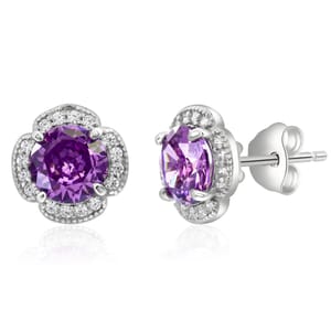 Silver stud earrings featuring round purple gemstones surrounded by small clear stones in a flower-like design.