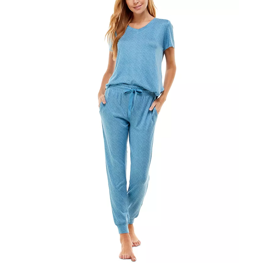 A woman is wearing a matching two-piece pajama set consisting of a short-sleeve blue tee and coordinating blue joggers with a drawstring waist.