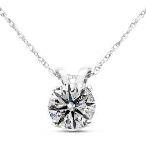 A 1/2 carat round diamond solitaire necklace features a brilliant-cut diamond set in a four-prong setting, suspended on a delicate, fine chain. The pendant and chain are crafted from a shiny metal, likely white gold or platinum.