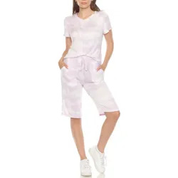 A woman is wearing a light purple tie-dye V-neck T-shirt and matching knee-length drawstring shorts with white sneakers.