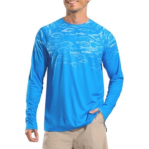 Blue long-sleeve sun-protection shirt featuring a fish pattern across the chest and shoulders, designed for UV protection. Worn with beige shorts.