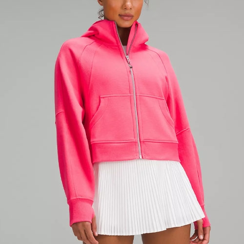Pink hooded sweatshirt with front pockets paired with a white pleated skirt.