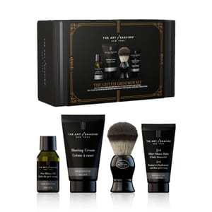 A shaving kit featuring pre-shave oil, shaving cream, a shaving brush, and after-shave balm, all unscented, packaged in a gift box.