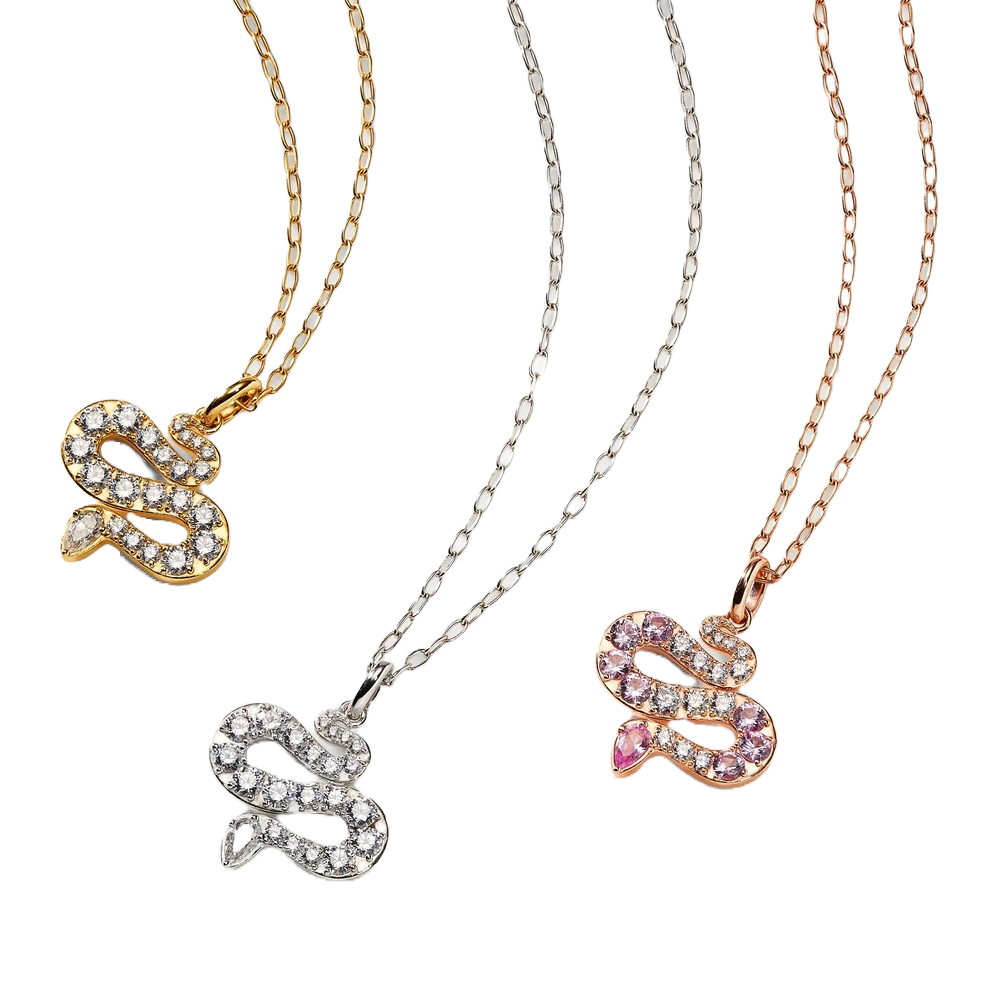 The Nadri Serpent Necklace features snake-shaped pendants adorned with sparkling stones, available in three metal finishes: gold, silver, and rose gold. Each pendant has a unique arrangement of clear and pink stones.