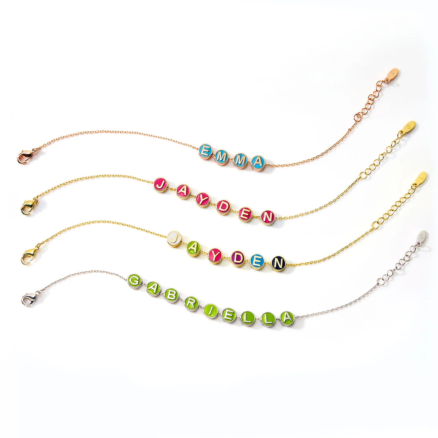 Four custom enamel slider charm bracelets with names \“EMMA,\“ \“JAYDEN,\“ and \“GABRIELLA\“ displayed in colorful circular charms on chains of different colors and clasp styles.