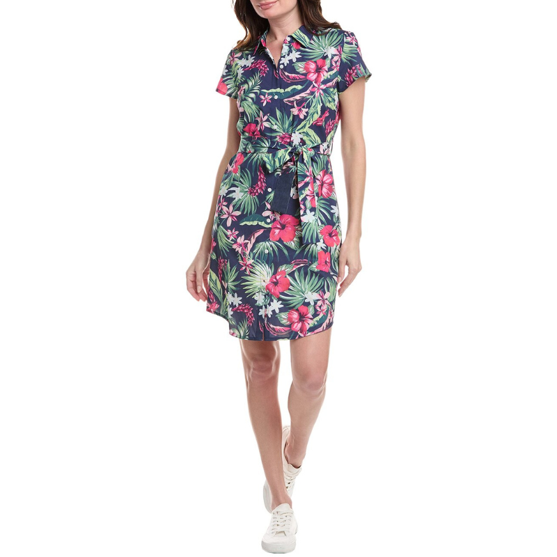 A navy blue shirtdress with a vibrant tropical floral print, featuring a collared neckline, short sleeves, and a waist tie. The dress is paired with white sneakers, creating a casual yet stylish look.