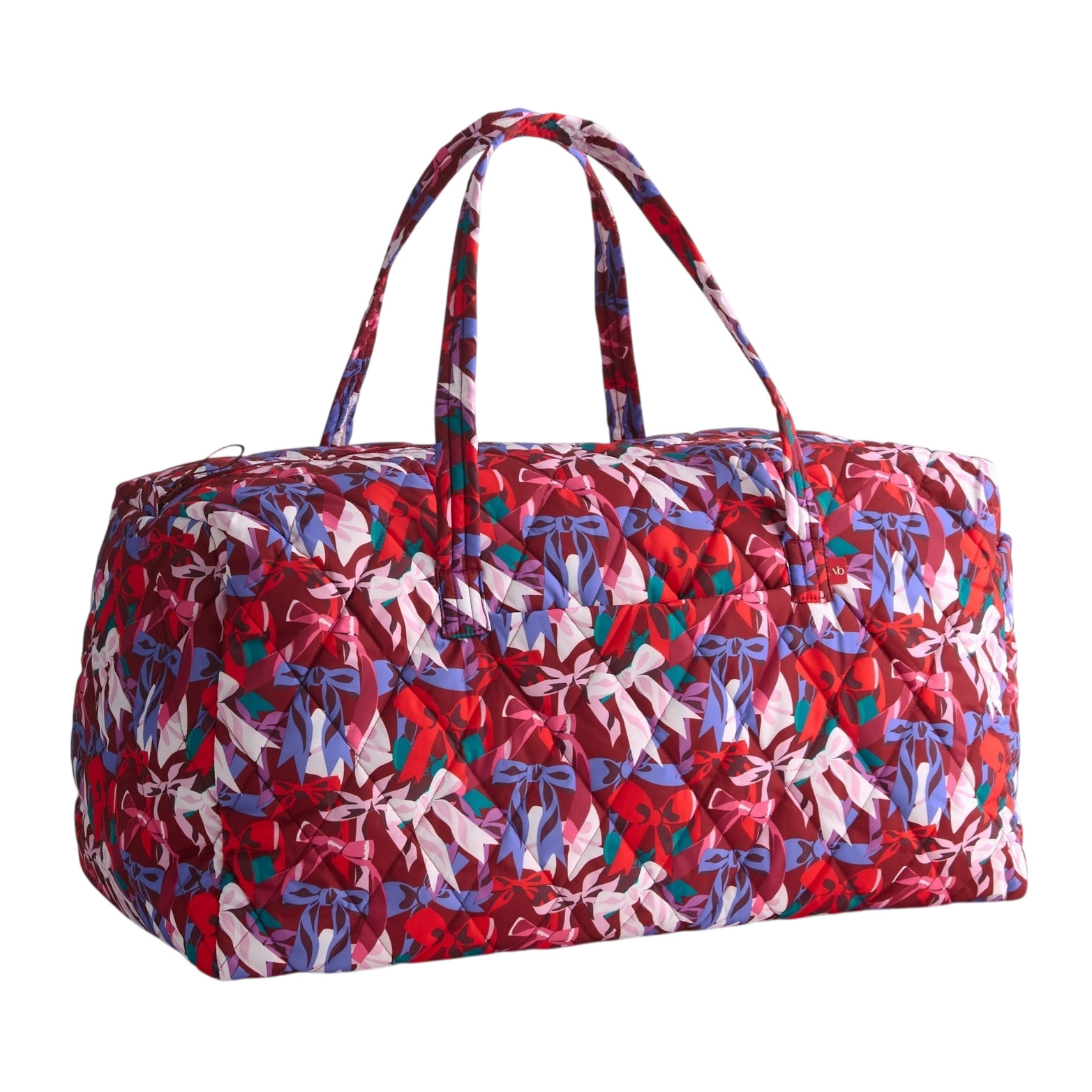 A quilted duffel bag with a colorful bow pattern in shades of red, purple, and white, featuring two handles for carrying.