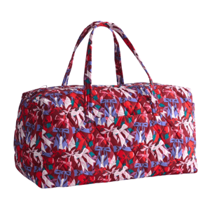 A quilted duffel bag with a colorful bow pattern in shades of red, purple, and white, featuring two handles for carrying.