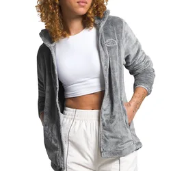 A person wearing a grey The North Face fleece jacket over a white crop top and light-colored pants.
