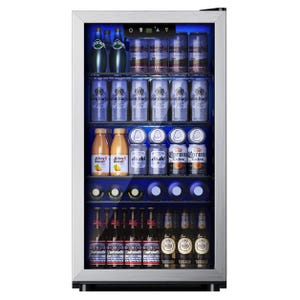 A beverage cooler is stocked with various drinks including Perrier water, Kronenbourg and other beer cans, Juicy Water bottles, Asahi and Corona Extra cans, Budweiser, and Warsteiner bottles.