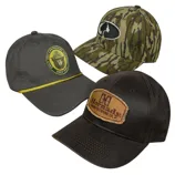 Three caps are shown: one dark with a \“Smokey Bear\“ patch and yellow cord, a camo hat with a tree logo, and a brown cap with a \“Hornady\“ patch.
