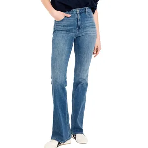 A person is wearing high-waisted, flared blue jeans paired with white sneakers.