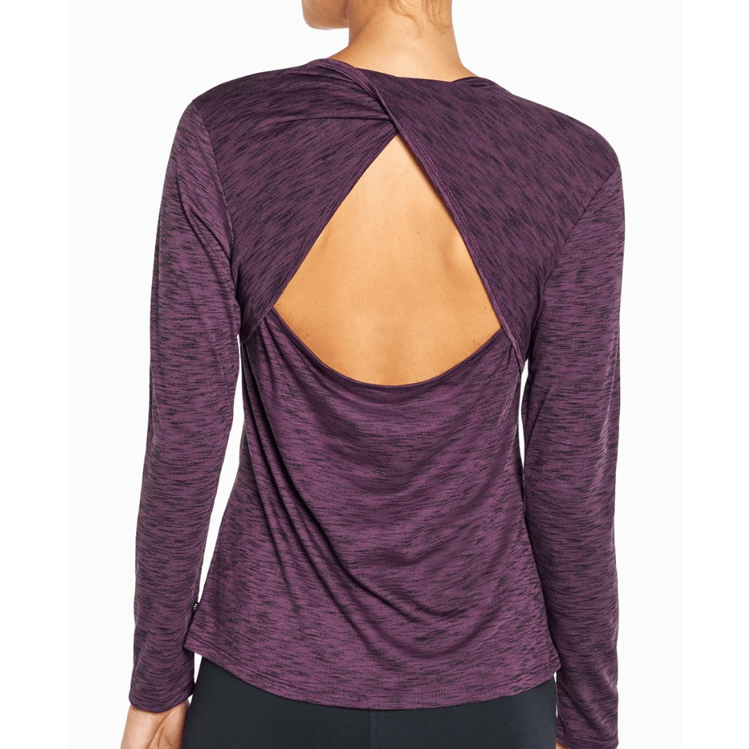 A woman is wearing a long-sleeved, maroon heathered top with an open back design.