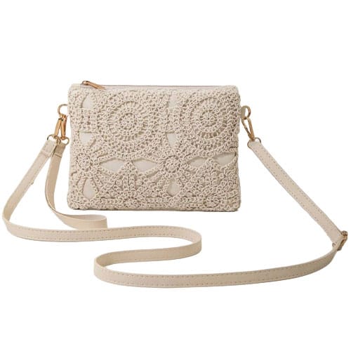 A cream-colored crochet clutch with a detailed floral pattern and a long, detachable strap.
