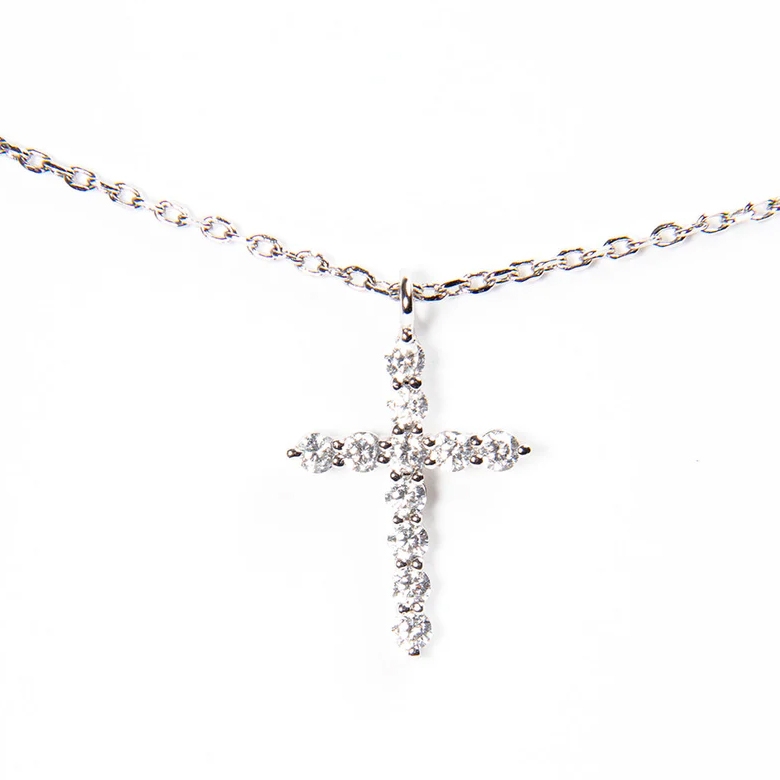A silver necklace with a cross pendant adorned with small round diamonds or diamond-like stones.