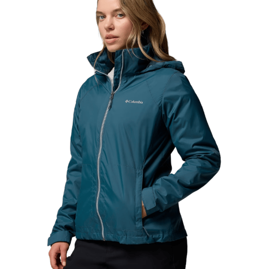 A woman is wearing a teal Columbia jacket with a front zipper, collared neckline, and hood.