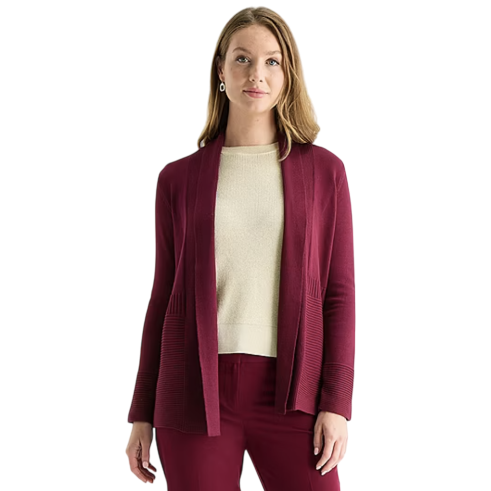 A woman wearing a burgundy open-front cardigan paired with a beige top and burgundy pants.