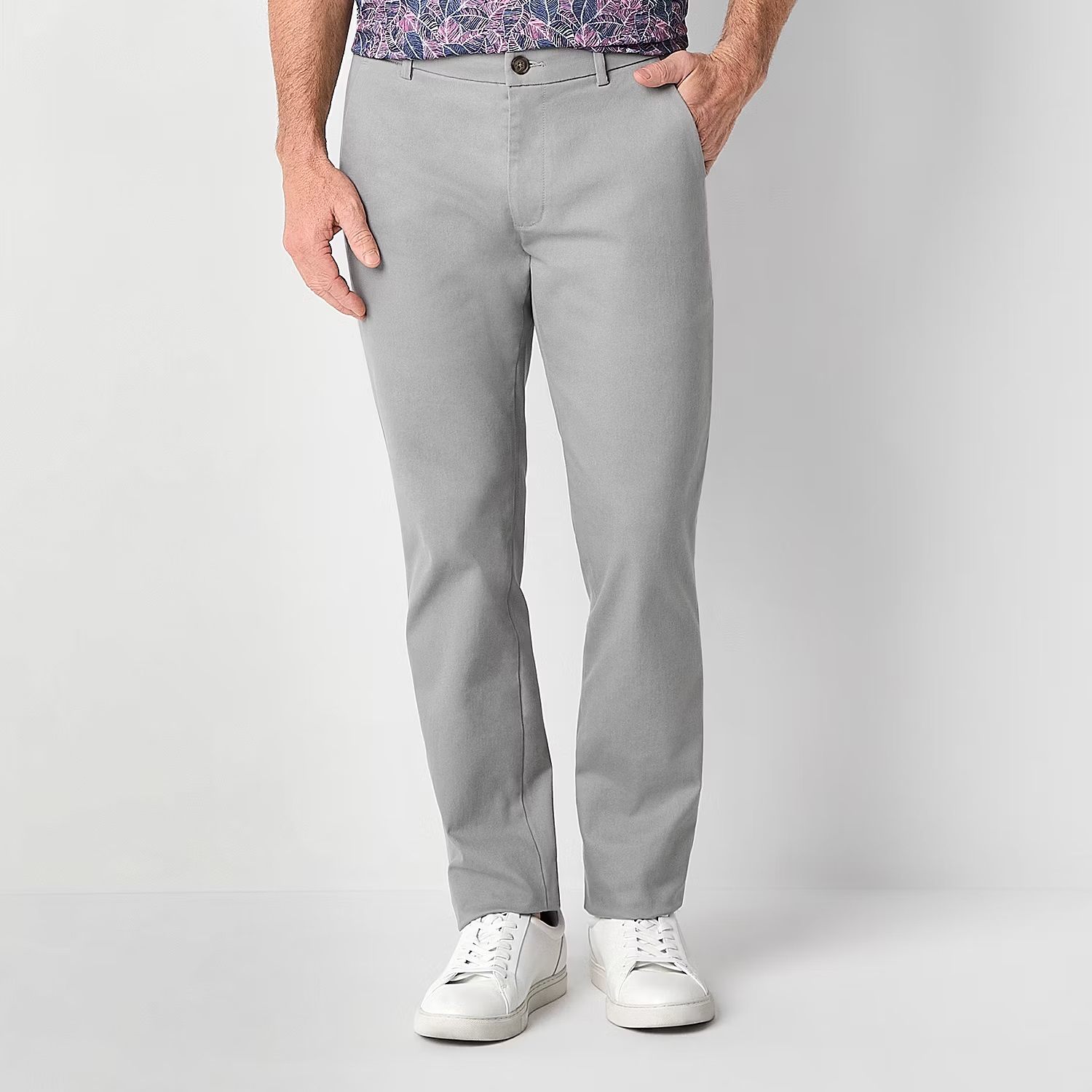 Gray chinos paired with white sneakers and a patterned shirt.