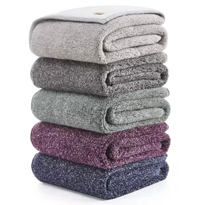 A stack of five folded towels in varying colors—light grey, dark grey, green, purple, and dark blue.