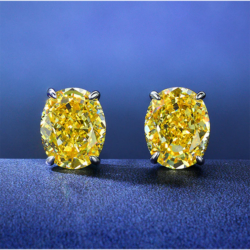 Yellow diamond stud earrings set in prongs, displayed against a blue background.