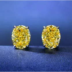 Yellow diamond stud earrings set in prongs, displayed against a blue background.