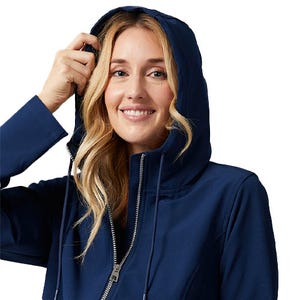 A woman is wearing a navy 32 Degrees hooded windbreaker featuring a front zipper, adjustable hood with drawstrings, and long sleeves.