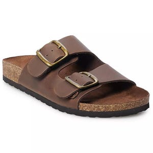 Brown Sonoma Buckle Sandals feature two wide straps with adjustable brass buckles, a cork footbed, and a black sole, offering a classic and comfortable design.