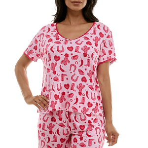 A short-sleeve, pink pajama set with red Valentine's-themed patterns, including cacti, horseshoes, hearts, and boots. The top has a rounded neckline with lace trim, matching the overall playful design.
