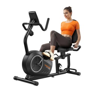 A person exercises on a Yosuda recumbent bike with a black frame, adjustable seat, backrest, and a digital display. The bike has a compact design with a belt drive mechanism for smooth pedaling.