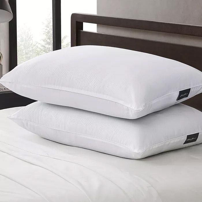 Two white bed pillows stacked on a bed.