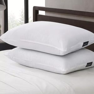 Two white bed pillows stacked on a bed.