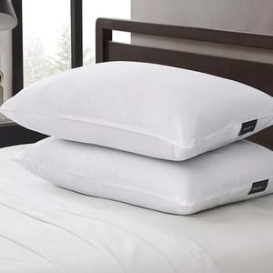 Two white bed pillows stacked on a bed.
