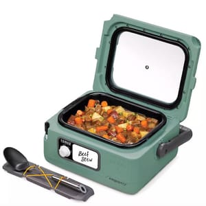 Portable slow cooker with a glass cover displaying beef stew inside, accompanied by a spoon and spork set.