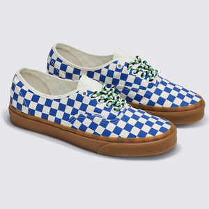 A pair of blue and white checkered canvas sneakers with green laces and a brown sole.