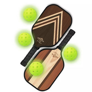 Two wooden pickleball paddles with geometric designs alongside three bright yellow perforated pickleballs.