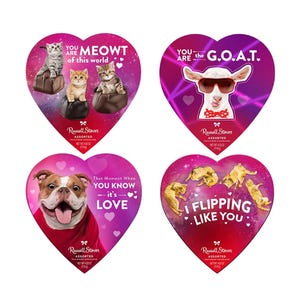 Four heart-shaped Russell Stover chocolate boxes feature playful designs: \“You are MEOWT of this world\“ with cats, \“You are the G.O.A.T.\“ with a goat, \“That Moment When You Know it's Love\“ with a dog, and \“I Flipping Like You\“ with dolphins.