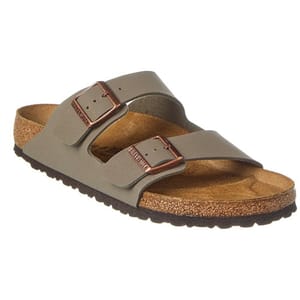 Tan leather sandals with two adjustable straps featuring metal buckles, set atop a cork footbed with a brown rubber sole.
