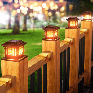 Solar-powered LED post cap lights mounted on a wooden fence, providing outdoor illumination.