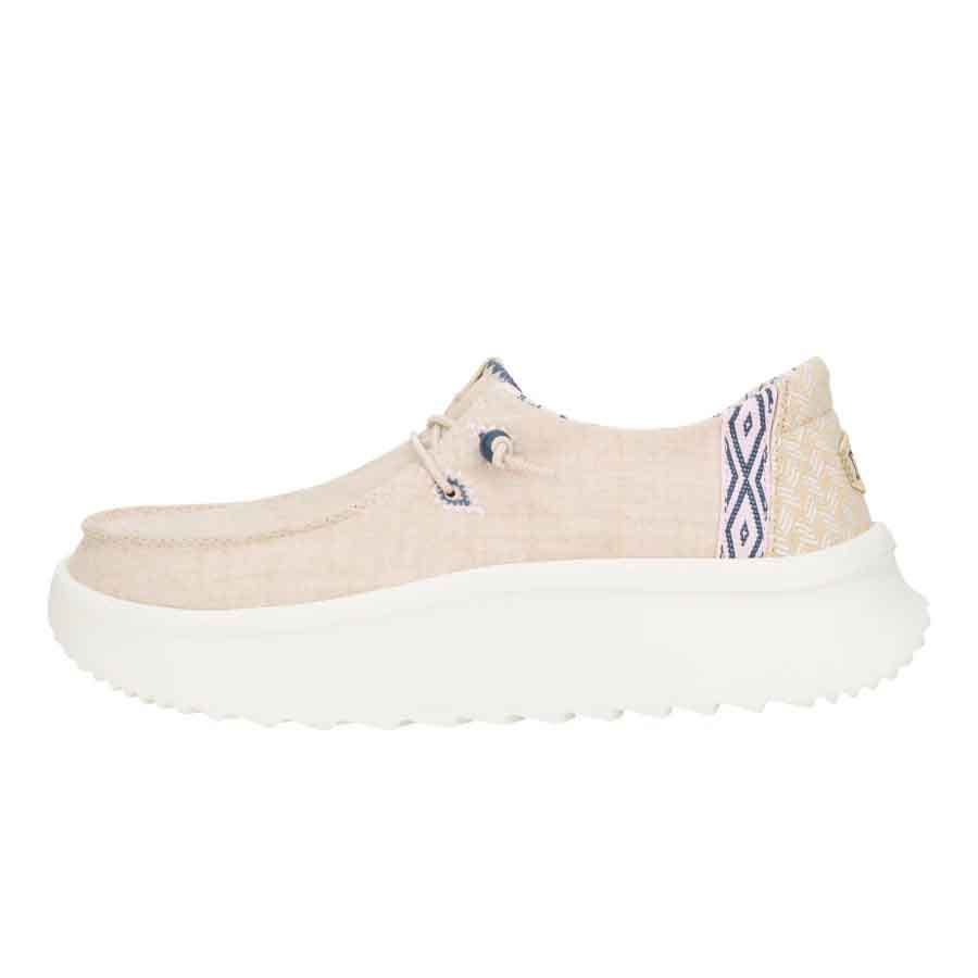 Beige slip-on shoe with woven fabric and a diamond-patterned heel detail, featuring a thick white cushioned sole for comfort and casual style.