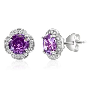 Silver and amethyst halo studs feature a round, purple amethyst center stone surrounded by a halo of small, clear gemstones set in a silver four-prong setting.