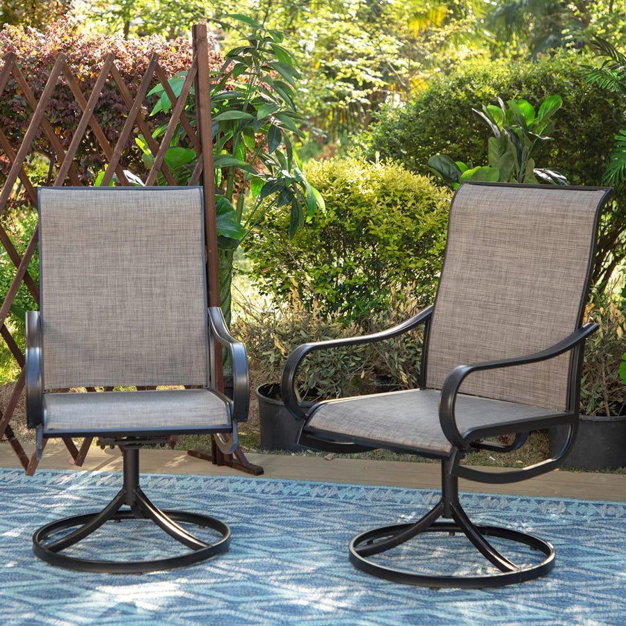 Two patio swivel chairs with metal frames and beige fabric, set in a garden.