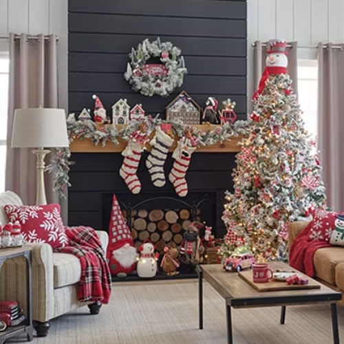 A set of four Christmas-themed miniature ski village houses, intricately designed and decorated with snow, is displayed on a mantelpiece.