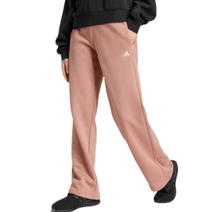 Adidas Cozy Pants are relaxed-fit, pink sweatpants with a white logo on the thigh, featuring side pockets and black shoes. They offer a comfortable, casual style.